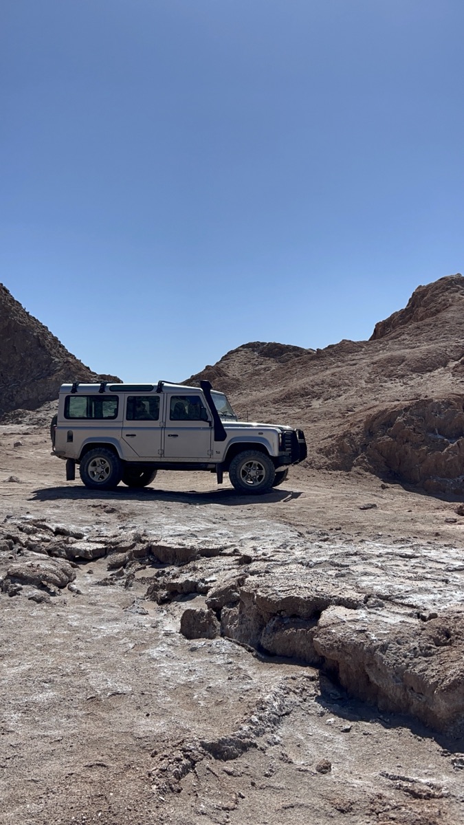 Defender 110 entre formações rochosas no deserto do Atacama